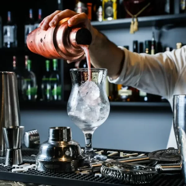 A bar manager in the bar management course pouring a drink